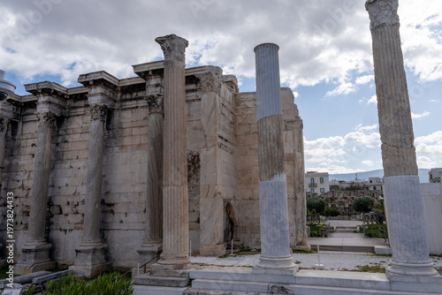 Obraz na plátně Close-up view of the majestic Corinthian columns and the surviving stone wall of Hadrian's Library under a cloudy sky in Athens, Greece