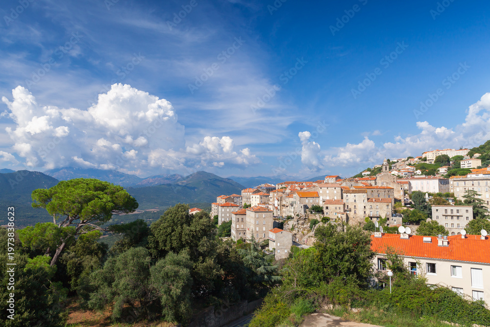 Fototapeta premium Sartene, Corsica, France. Panoramic view the of old town under bright blue sky with white clouds