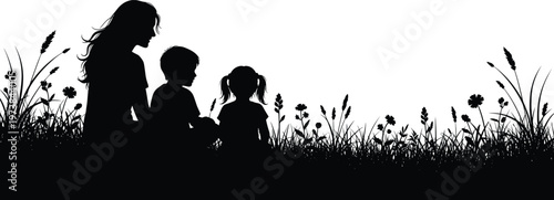 Black silhouette of a mother sitting with her son and daughter in a field of tall grass and wildflowers, family.