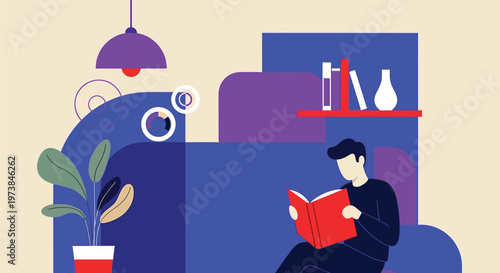 A man sits on a couch reading a book in a modern living room.