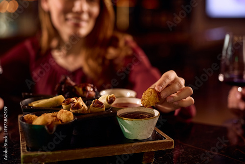 Close up of woman eating in tapas bar.