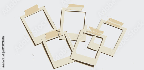 Blank vintage instant photo frames with tape attached, laid out in a scattered arrangement on a white surface, evoking nostalgia and memories