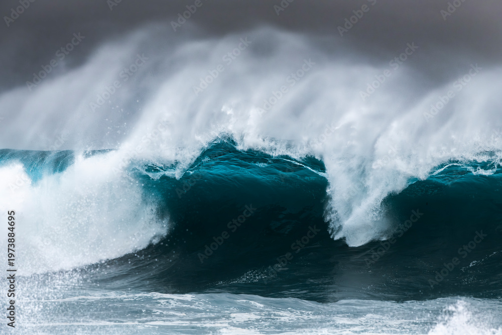 Obraz premium Large ocean wave breaking during heavy swell just after a storm at sunrise, Bronte Beach, Sydney, Australia.