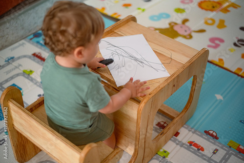 Left-handed baby drawing with crayon