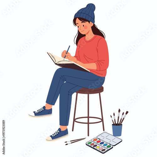 Artist girl sitting on stool painting with watercolors in sketchbook wearing blue beanie.