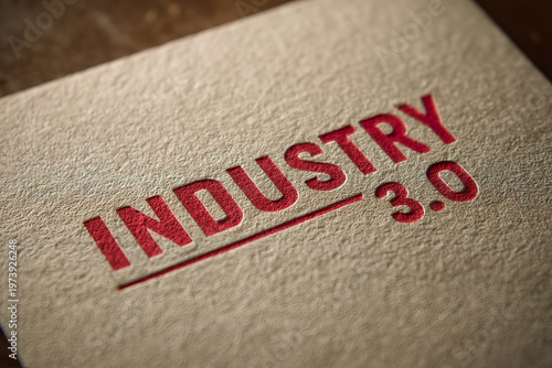 Textured paper shows bold red letters. Industry 3.0 stamped with crisp, modern design. Red ink contrasts warmly against beige surface. Close-up emphasizes tactile quality and professional tone