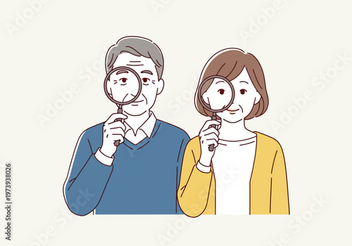 Senior couple looking through magnifying glasses