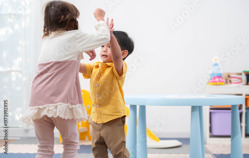 Two children playing and running happily indoors