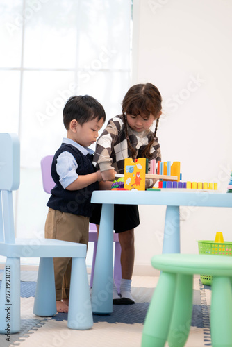 Little boy and girl playing with toys together in the playroom