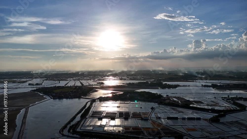 Aerial View of Silhouetted Salt Pans at Sunset with Sparkling Water Reflections in Indonesia
