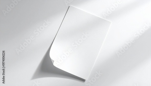 Crisp white blank paper mockup with a slightly bent corner, set against a pristine background bathed in artistic light and shadow play