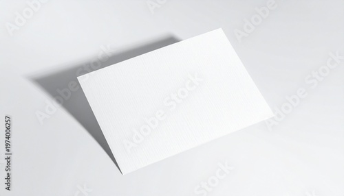 A blank white postcard casting a shadow on a plain white surface, ideal for design and promotional use