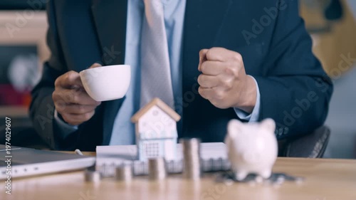 Successful businessman celebrating home loan approval with clenched fists and happy gesture.