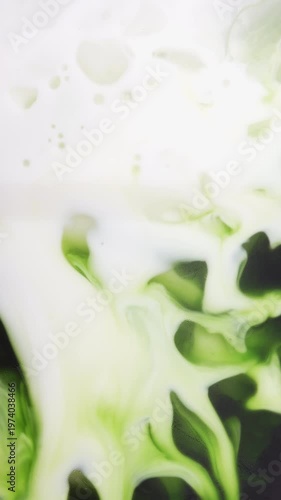 4K Vertical video Abstract green tea or matcha liquid mixing with milk creating smooth swirling patterns Organic fluid texture with vibrant green tones, ideal for beverage concept background and moder