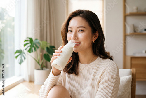 Asian woman gracefully enjoying a fermented milk drink