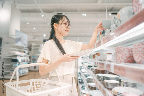 Konstfotografi Smiling asian woman shopping choosing plate product for home at indoors japan st