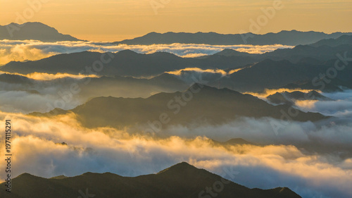 Obraz na plátně Layered mountain ranges covered by a sea of clouds at sunrise in northern China