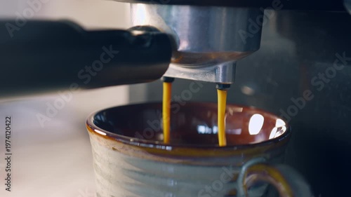 Slow motion espresso coffee pouring from machine into ceramic cup for fresh morning breakfast.