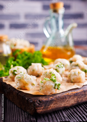 raw chicken balls on wooden board