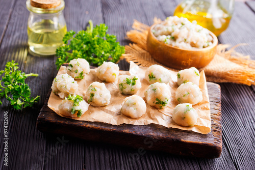 raw chicken balls on wooden board
