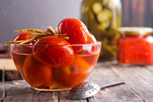 Assortie Jars of Marinated vegetables picles tomato on a wooden background