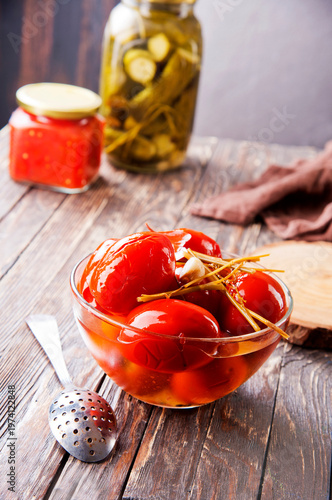 Assortie Jars of Marinated vegetables picles tomato on a wooden background