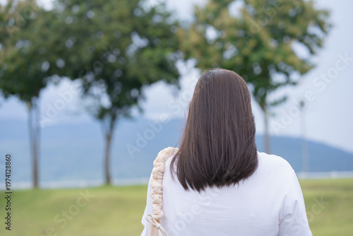 Relax and wellness concept with woman walk on road in garden and mountain background at chiangmai thailand in raining season