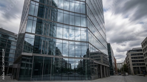 Urban glass building reflecting sky and moving clouds