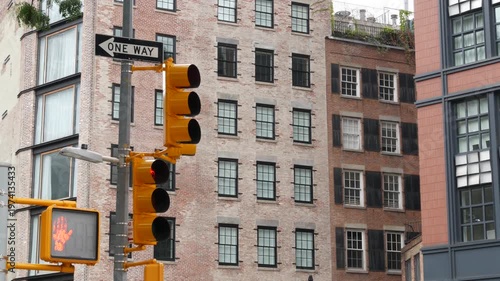 New York City Lower Manhattan, United States. Urban road sign of american street, traffic sign in NYC. Red brick building architecture, Tribeca district. One way arrow and yellow traffic light.