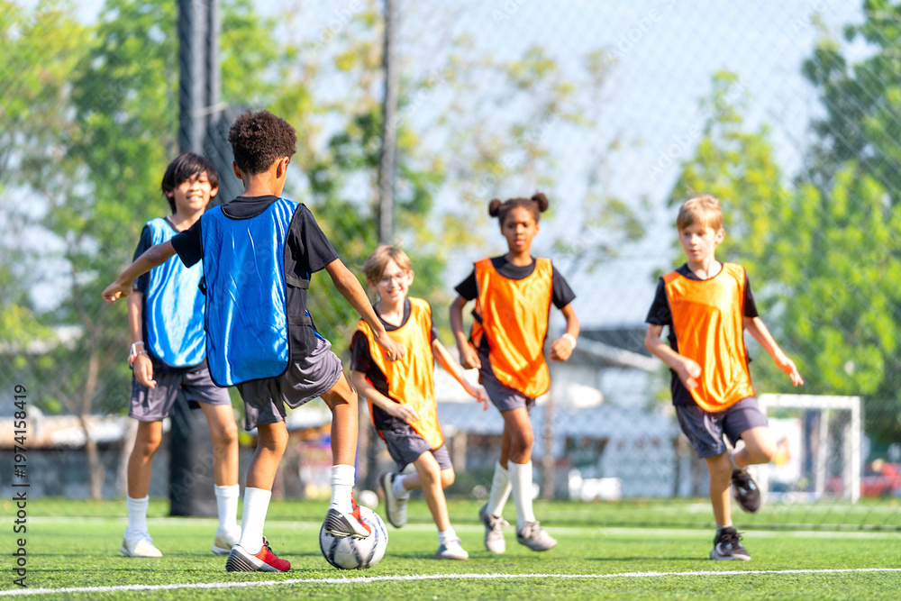 Obraz premium Group of boys and girls enjoy to practice to play soccer together in the field with day light and they look happy to exercise to get good health.