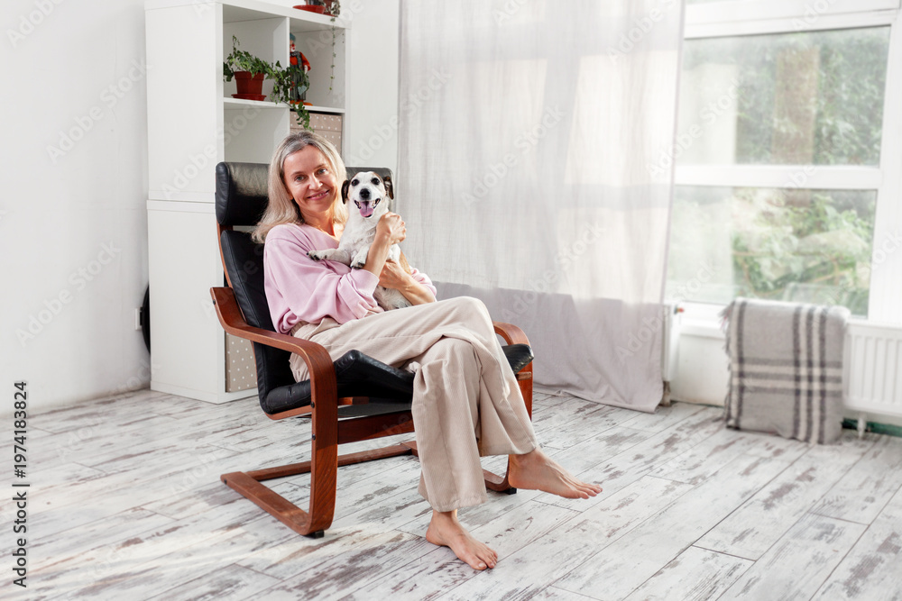 Fototapeta premium Woman sitting at white home with Dog