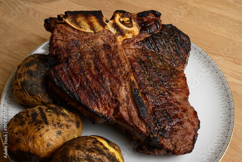 Grilled Bistecca alla Fiorentina Large, Whole, Italian T-Bone Steak with Potatoes