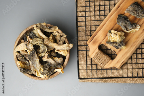 Crispy salmon skin snacks on a wooden board  burlap. Perfect for food blogs, restaurant menus, seafood advertisements, or culinary websites.