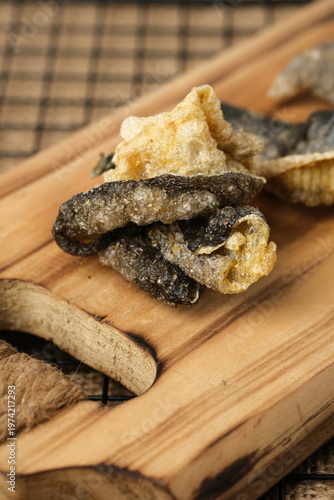 Crispy salmon skin snacks on a wooden board  burlap. Perfect for food blogs, restaurant menus, seafood advertisements, or culinary websites.