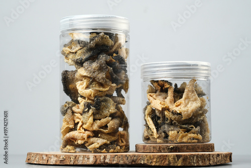 Two jars full of salmon fish skin chips snacks ideal for seafood snack branding, innovative snack packaging, and fish skin product ads.