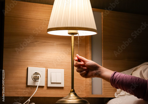 Canvastavla Woman hand turning on or turning off switch the minimal lamp in modern bedroom