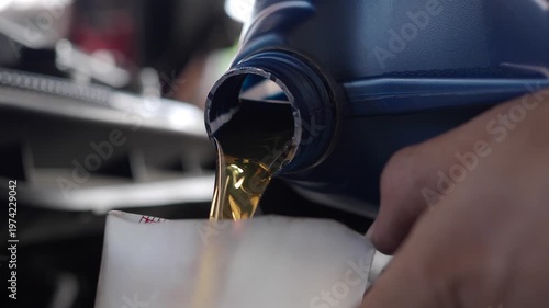 Mechanic changes the engine oil at a car repair shop.