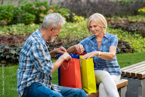 Happy senior couple with shopping bags after shopping
