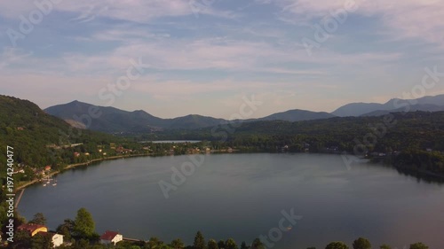 Aerial sunset view of Avigliana, Italy, Piedmont , Turin,Italy A beautiful town with a medieval castle and red-roofed houses, surrounded by the green hills of Susa and trees on a sunny day.