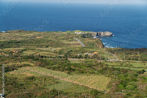 A breathtaking coastal landscape at Cape Hedo, the northernmost point of Okinawa, Japan. The dramatic cliffs meet the vast blue ocean, creating a sense of isolation, freedom, and connection with natur
