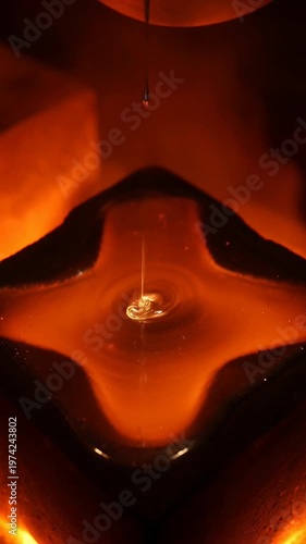Molten metal pouring star-shaped mold in fiery foundry