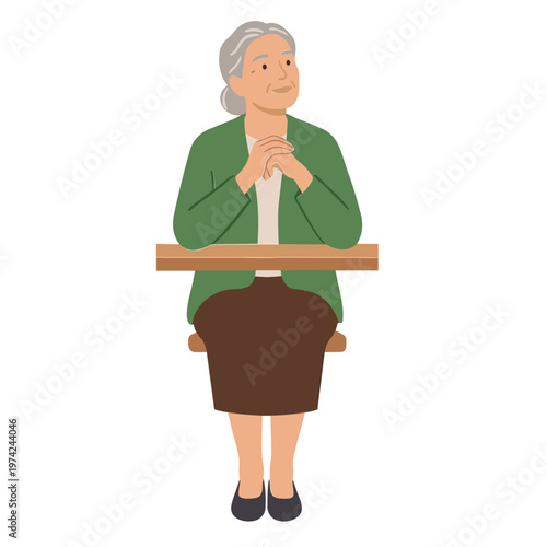 An elderly woman sitting on a chair with her hands clasped at a table.
