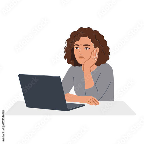 Woman sits at desk with laptop looking worried and stressed