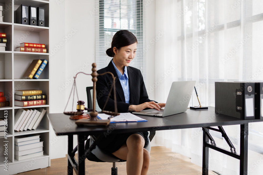 Fototapeta premium Female lawyer working on laptop in law office