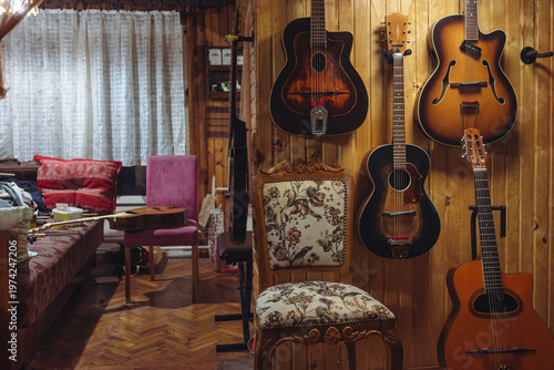 Old jazz acoustic guitars on the wooden wall in the room