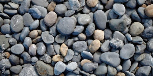 The pebbles on a coastal shore displaying smooth rounded gray stones in natural pattern