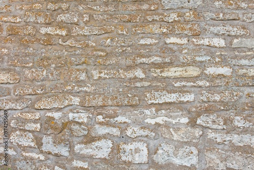 Close-up of weathered stone wall composed of unevenly shaped natural stones in summer, Muhu, Estonia, Europe.