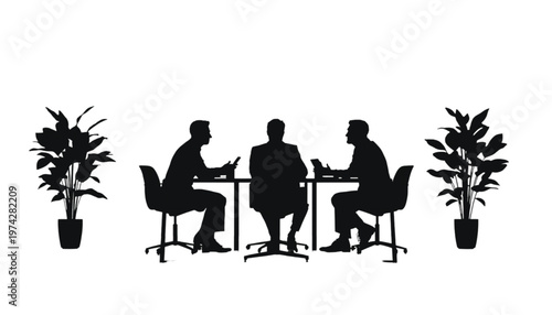 Three business professionals engage in a focused discussion at a table, flanked by decorative potted plants.