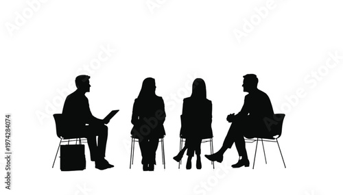 Four individuals sit in chairs facing each other, in a formal setting, suggesting a discussion or interview.