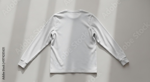 A Plain White Long-Sleeved T-Shirt Laid Flat in Natural Light with Soft Shadows